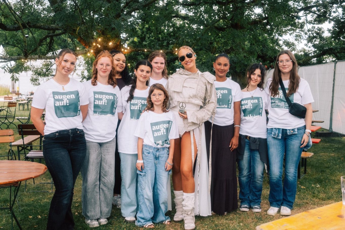 Sarah Connor mit SchülerInnen aus dem Netzwerk augen auf! Eine Gruppe von SchülerInnen steht mit Sarah Connor vor einem Baum
